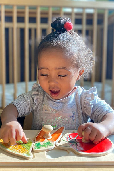 Learning Paths Academy, Toddler Explorer Program, Little girl playing with a puzzle