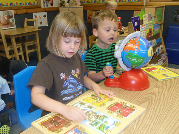 Learning Paths Academy, Preschool Readiness Enrichment Program (PREP), Little boy playing with globe and little girl playing with puzzle